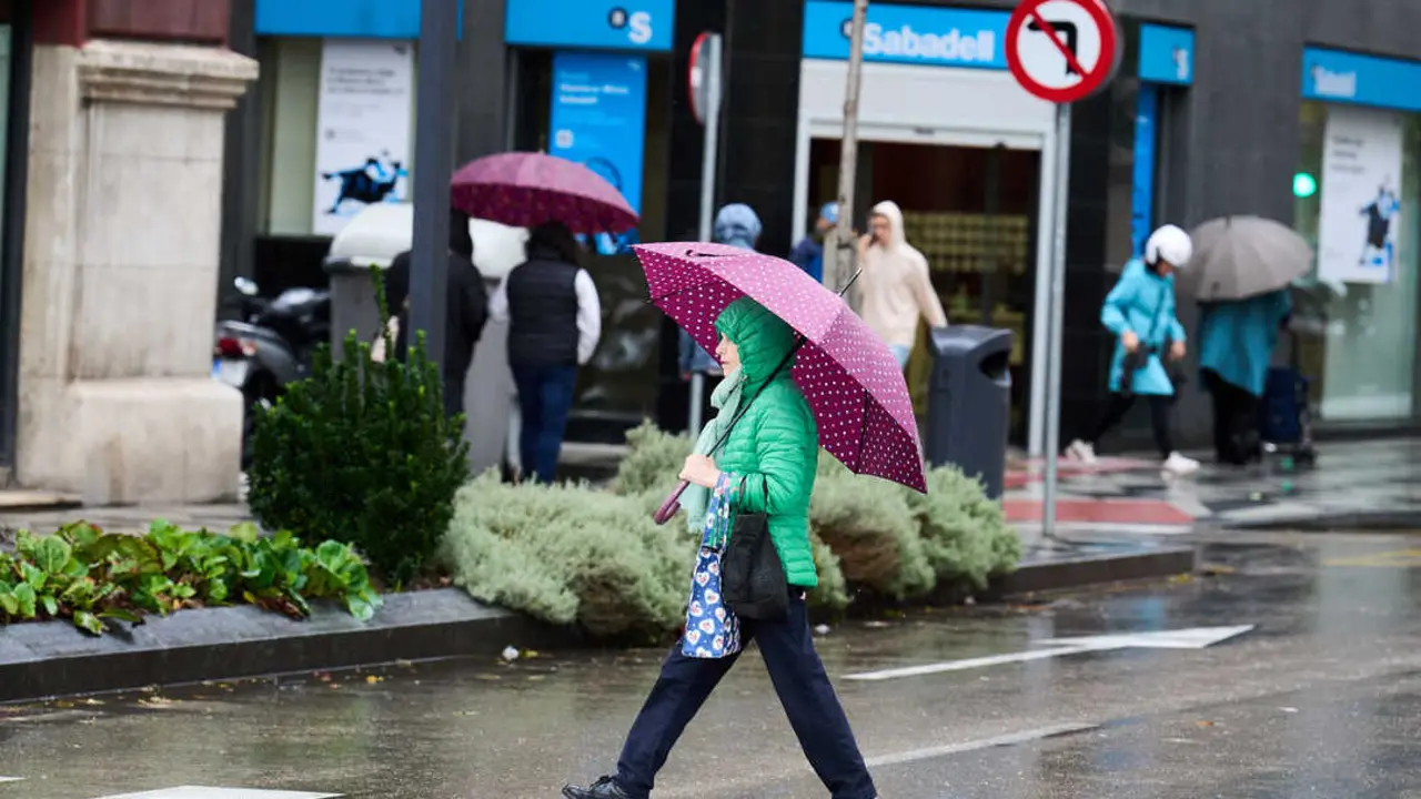 Una persona se cubre de la lluvia y el viento con paraguas. / EP