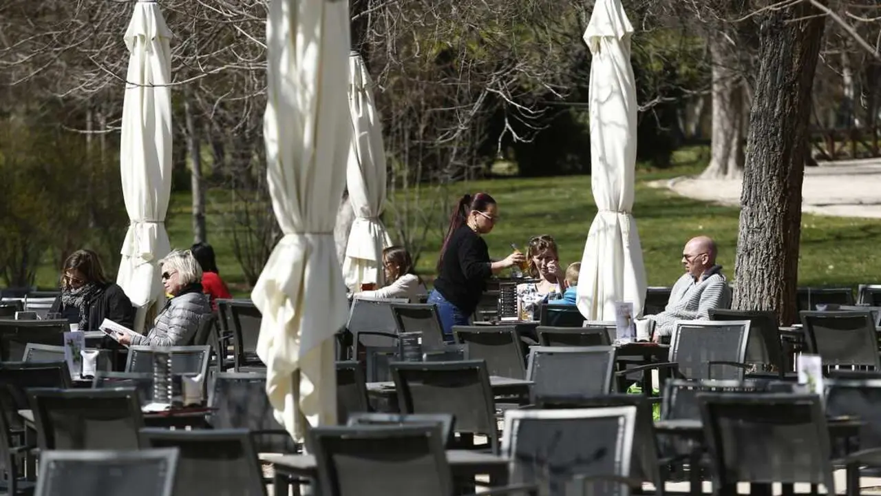 Una camarera sirve a varios clientes en una mesa de una terraza. / alerta