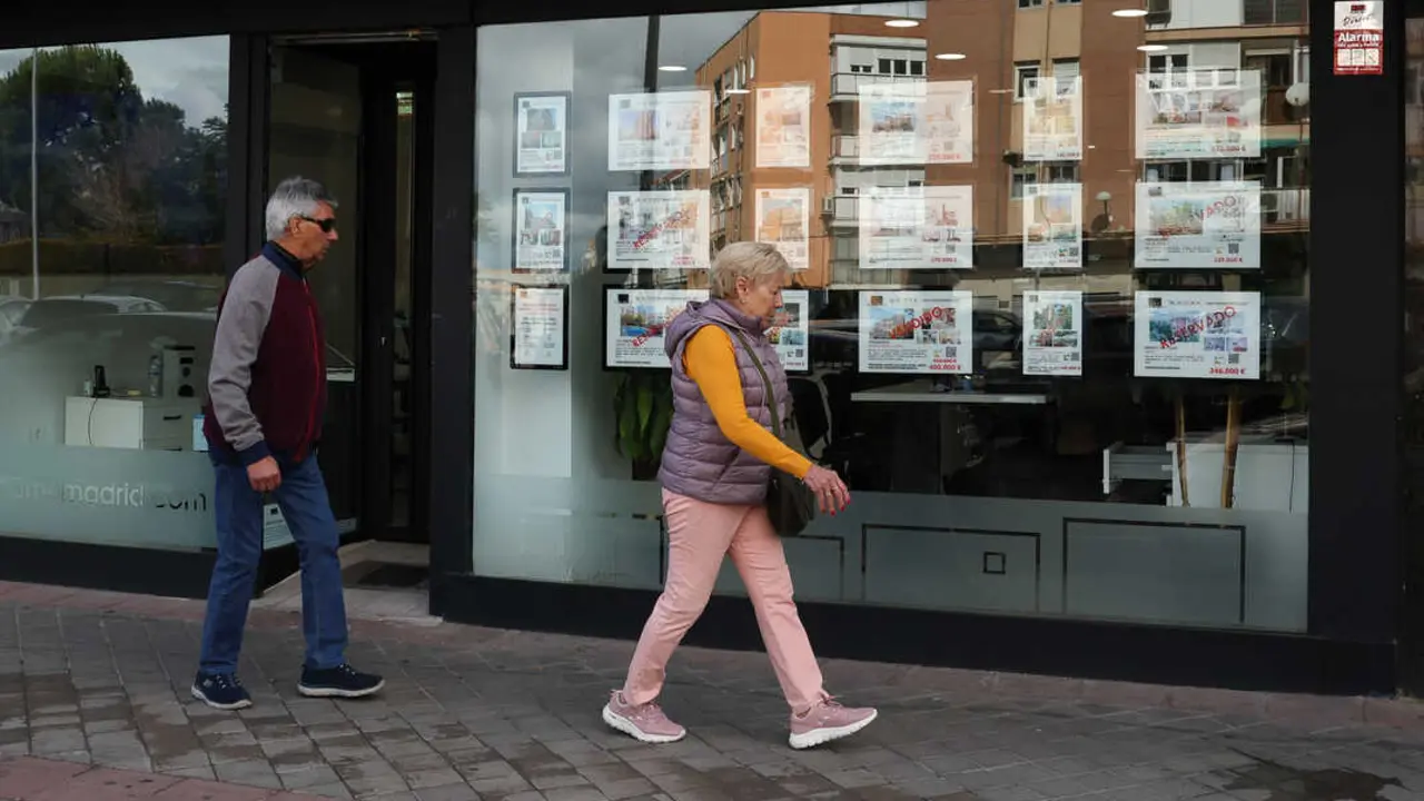 Dos personas pasan por una inmobiliaria. / EP