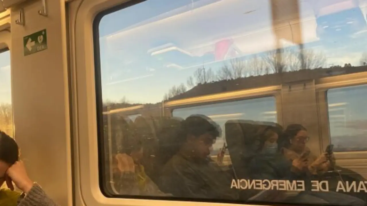 Pasajeros del Alvia Santander-Madrid, reflejados en la ventana del convoy, durante una de las m&uacute;ltiples paradas que sufri&oacute; el tren por incidencias en la infraestructura. Algunos usuarios trataron de mantenerse informados a trav&eacute;s del m&oacute;vil, mientras el ambiente oscilaba entre la resignaci&oacute;n y la tensi&oacute;n./ ALERTA