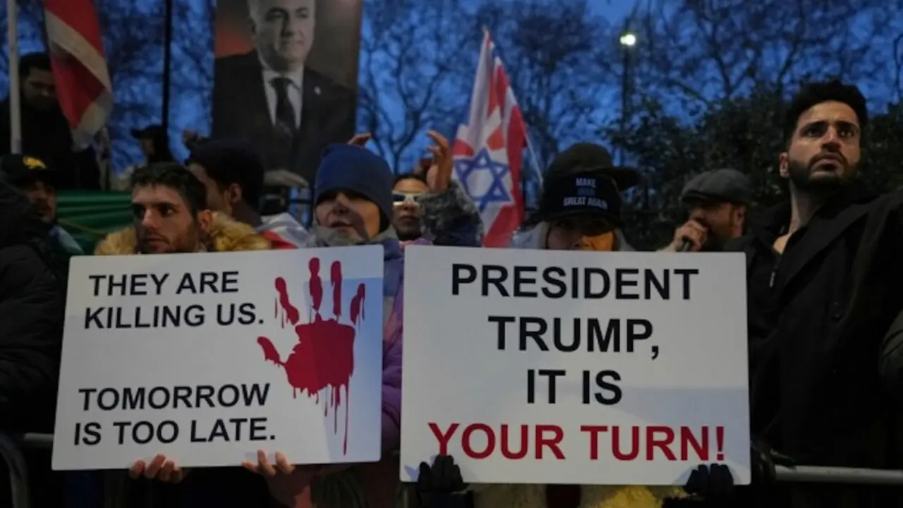 Manifestantes sostienen pancartas y banderas frente a la embajada de Ir&aacute;n en Londres, el lunes 12 de enero de 2026.