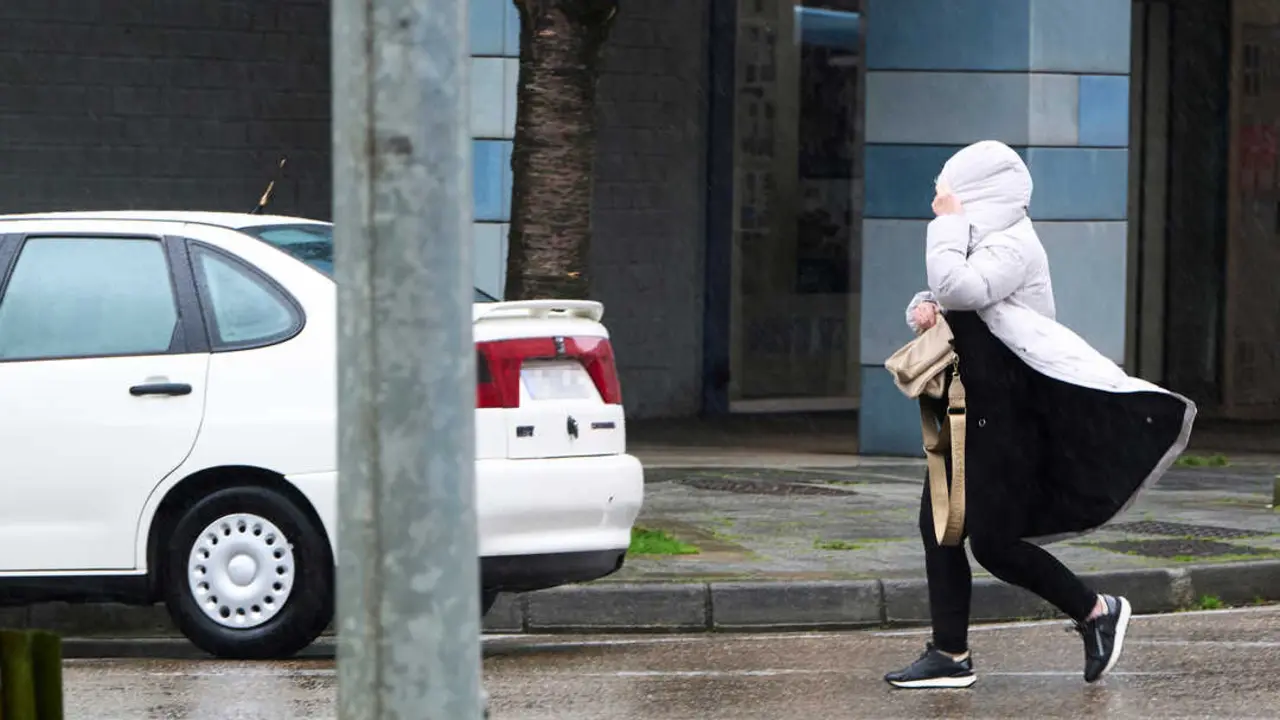 Una persona camina por una calle de Santander un d&iacute;a de viento. / EP