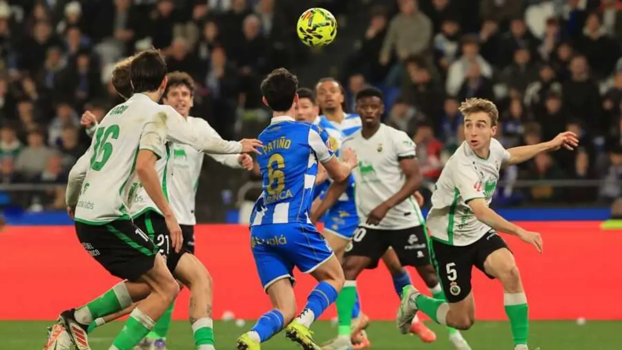 Los jugadores de Racing y del Depor se disputan un bal&oacute;n. / LH