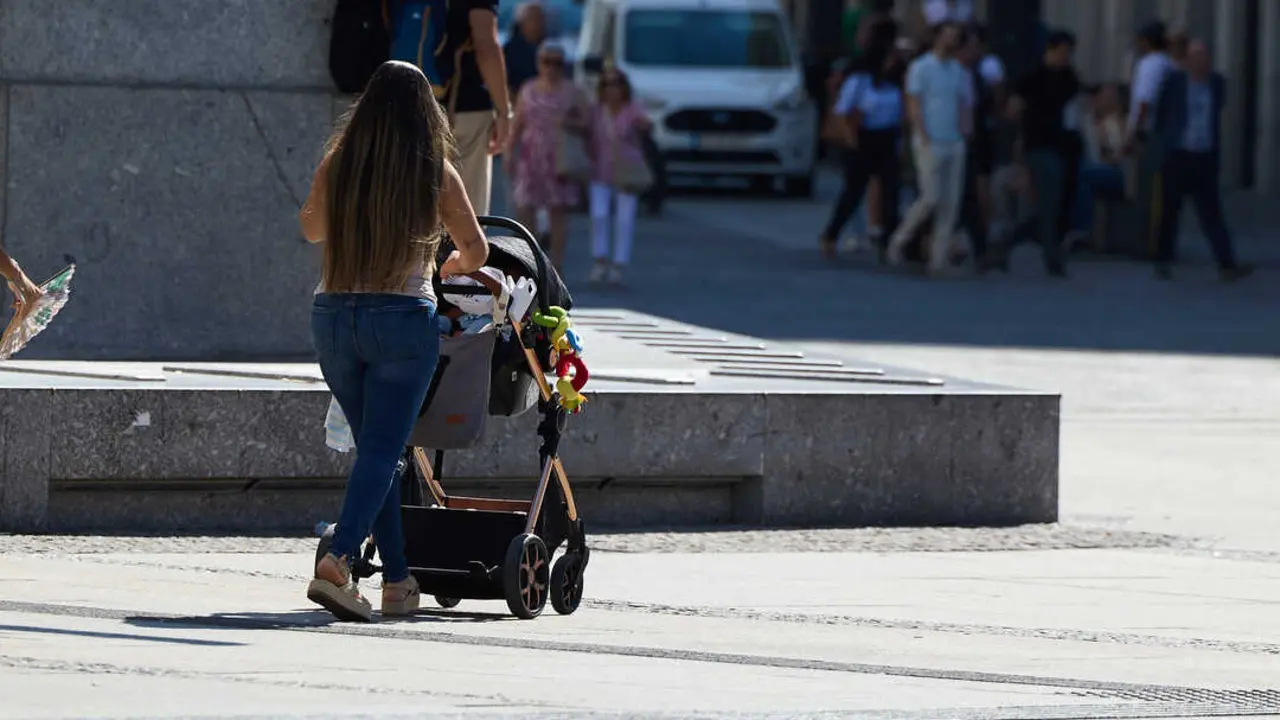 Una mujer camina por la calle con un carrito de beb&eacute;. / EP