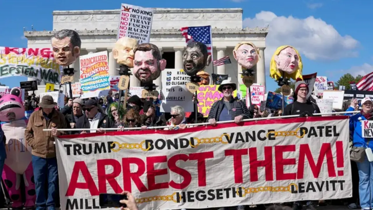 Manifestantes participan en una protesta del movimiento #NoKings frente al Lincoln Memorial, en Washington, con pancartas y mensajes contra l&iacute;deres pol&iacute;ticos y el poder institucional.