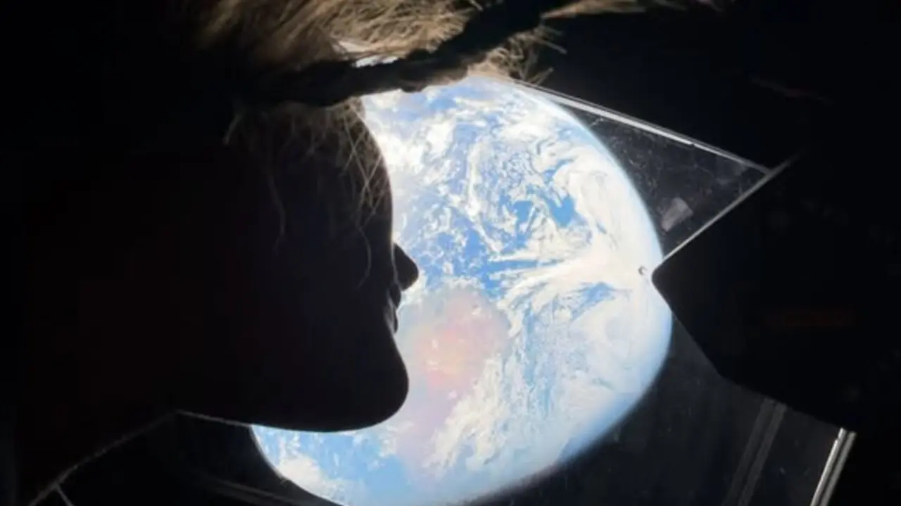 La Tierra, vista desde la ventanilla de la c&aacute;psula Ori&oacute;n, ilumina los rostros de los astronautas Christina Koch y Reid Wiseman en una imagen que simboliza el v&iacute;nculo humano con su hogar desde el espacio profundo.