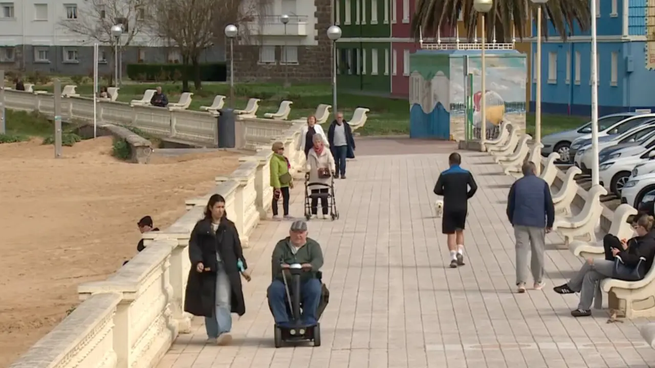 Vecinos pasean por el entorno mar&iacute;timo de Laredo en una jornada tranquila junto a la playa de la villa c&aacute;ntabra. / RTVE