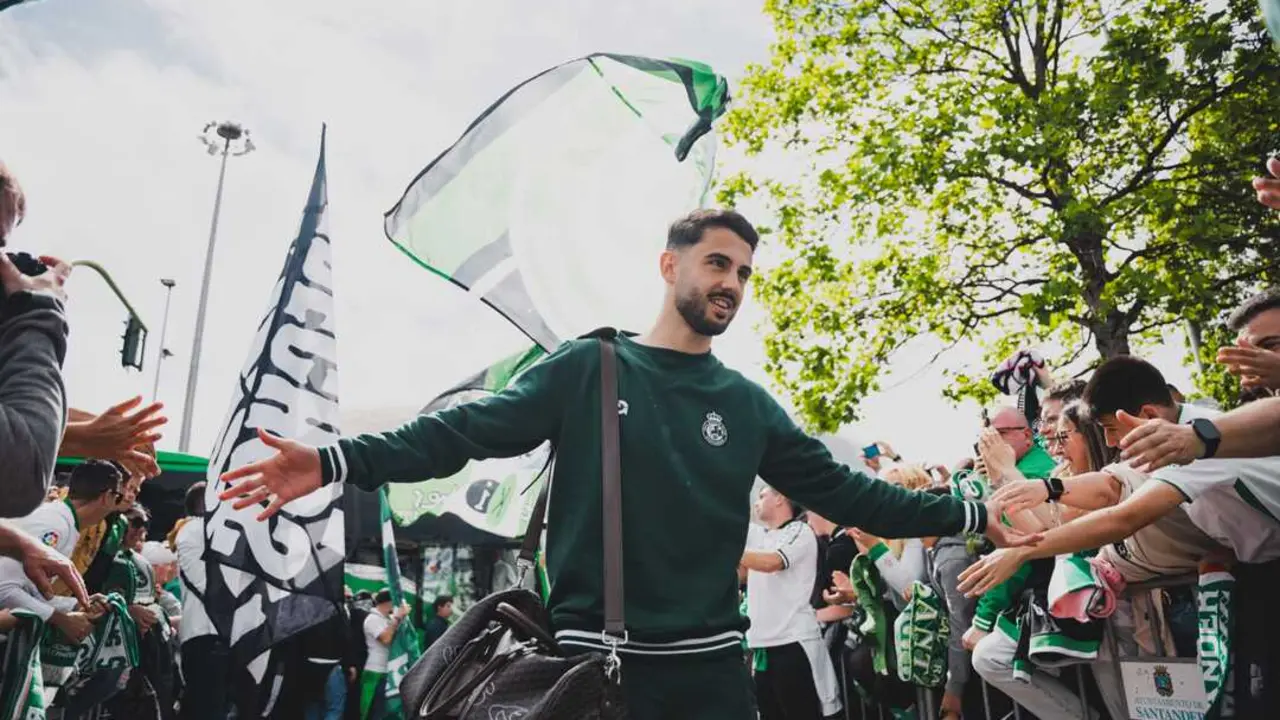 Un jugador del Racing saluda a la afici&oacute;n a su llegada a El Sardinero en medio de un recibimiento espectacular marcado por las banderas, los c&aacute;nticos y la ilusi&oacute;n del racinguismo.