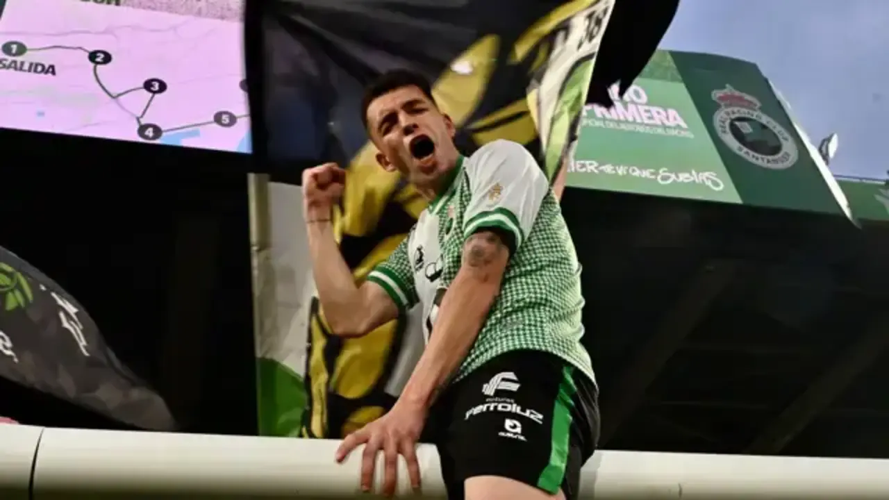 Un futbolista del Racing celebra el ascenso con una bandera verdiblanca mientras El Sardinero corea el regreso a Primera Divisi&oacute;n.