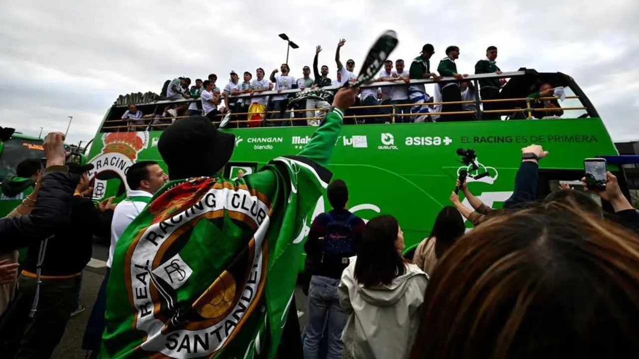 La plantilla del Racing celebra el ascenso a Primera Divisi&oacute;n desde el autob&uacute;s descapotable durante la multitudinaria r&uacute;a por las calles de Santander, arropada por miles de aficionados verdiblancos.