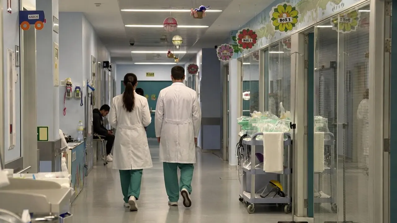 Dos profesionales sanitarios recorren uno de los pasillos hospitalarios de Cantabria en plena escalada de la huelga m&eacute;dica, marcada por la tensi&oacute;n asistencial y el enfrentamiento entre administraciones y sindicatos.