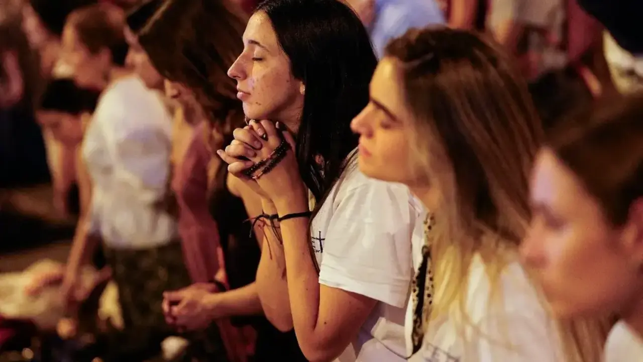 J&oacute;venes participan en un momento de oraci&oacute;n y recogimiento durante la vigilia presidida por el papa Le&oacute;n XIV en Madrid, ante cientos de miles de asistentes congregados en la Plaza de Lima y el Paseo de la Castellana.