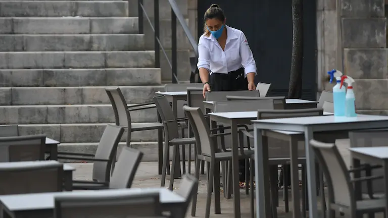 Una trabajadora de la hosteler&iacute;a prepara las mesas antes de empezar la jornada. / Hardy