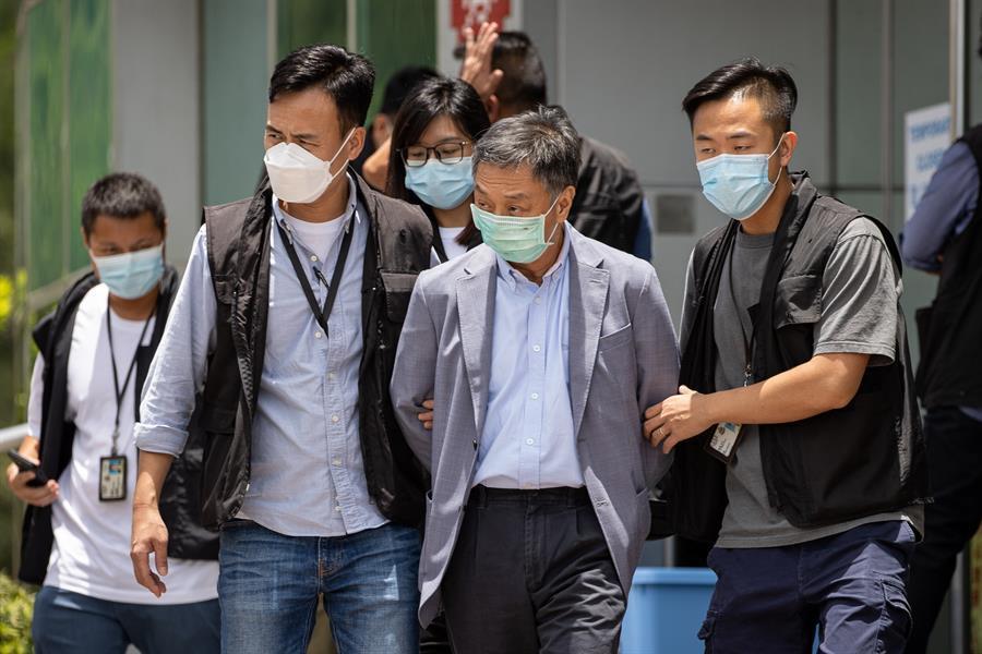 El editor jefe del Apple Daily, Ryan Law (izquierda), es escoltado por la policía al salir de la oficina de Next Media, editora del Apple Daily, en Hong Kong, China, el 17 de junio de 2021. La policía de seguridad nacional de Hong Kong detuvo a Law y a otros cuatro directores del periódico Apple Daily bajo la sospecha de conspiración para coludir con fuerzas extranjeras en virtud de la legislación impuesta por China. EFE/EPA/JEROME FAVRE