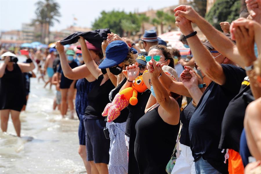 Miles de murcianos se han dado cita este mediodía en las orillas del Mar Menor, formando una cadena humana y guardando luto a la laguna salada. La iniciativa, ha sido organizada por la plataforma ILP Mar Menor, y los manifestantes han abrazado de manera simbólica los 73 kilómetros que componen la zona., en la imagen, representantes del PSOE de Murcia que se han sumado a la iniciativa en la Playa de Los Alcázares. EFE/Juan Carlos Caval