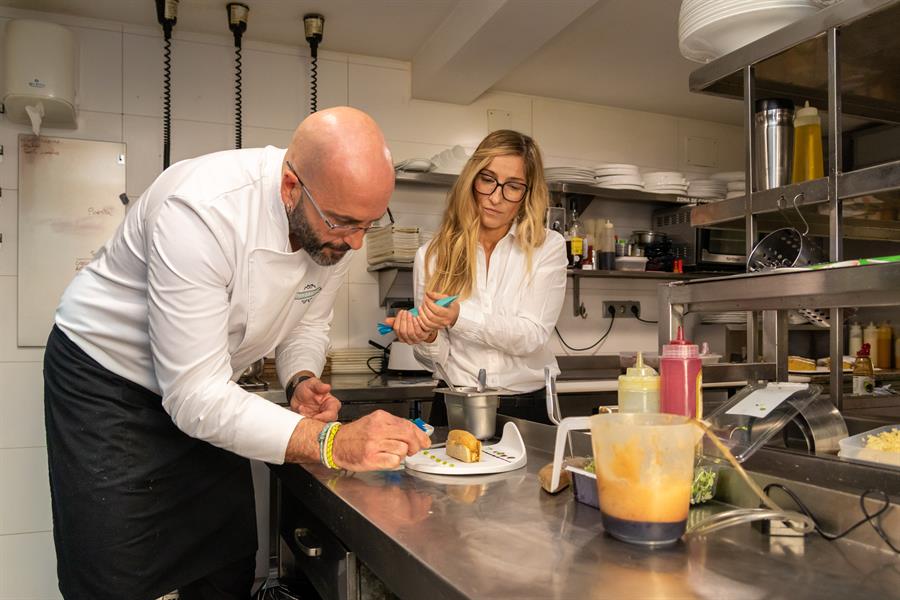 Belén Morquillas y el chef Urko Arenaza emplatando en la cocina de la sala del Pasaje de los Nobles de Santillana del Mar, que cumple cien años de funcionamiento en manos de la cuarta generación de la misma familia, una historia de la que habla con EFE Belén Morquillas, al frente ahora del restaurante.-EFE/Javier G. Paradelo