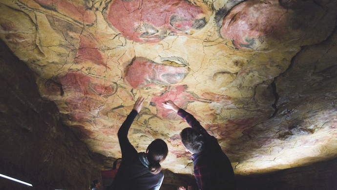 Dos visitantes en la reproducción de la cueva de Altamira.