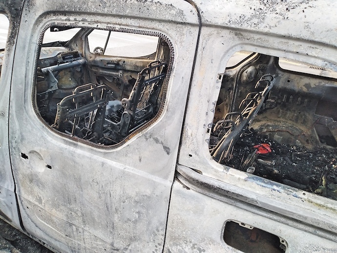 Restos carbonizados de vehículos tras una serie de incendios intencionales durante el verano de 2022.