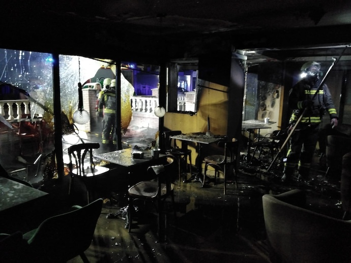 Bomberos del Servicio de Emergencias 112 del Gobierno de Cantabria trabajando intensamente para controlar el voraz incendio en la terraza de un local hostelero en Laredo durante la madrugada del 28 de mayo, evitando que las llamas se propagaran a las viviendas situadas encima del establecimiento. / A.E.