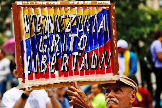 Libertad. Un hombre con un cartel en el que se lee ‘Venezuela gritó libertad’, con los colores de la bandera de Venezuela.