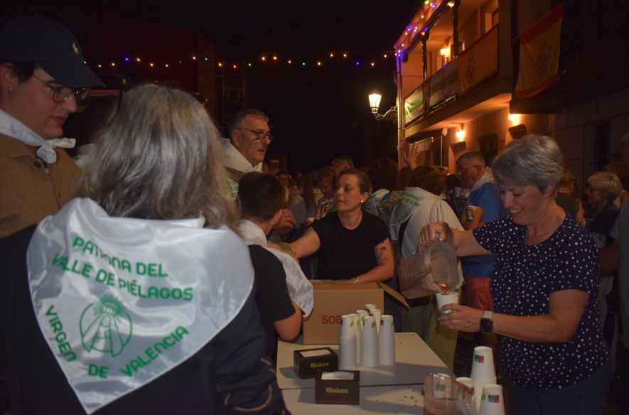 Los vecinos reparten bebidas entre los asistentes a la celebración en Piélagos. / A.E.