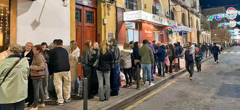 Personas haciendo cola en la puerta de la chocolatería Áliva. / ALERTA