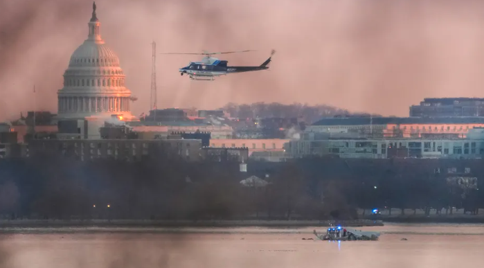 Un helicóptero vuela cerca del lugar del accidente del avión de American Airlines en el río Potomac, luego de que el avión se estrellara al acercarse al Aeropuerto Nacional Reagan en Arlington, Virginia, el jueves.