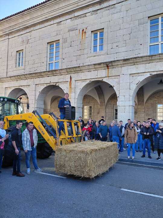 Un ganadero utiliza un tractor y un fardo de paja como improvisado estrado para lanzar su mensaje ante el Parlamento de Cantabria: "No queremos desaparecer, solo subsistir".