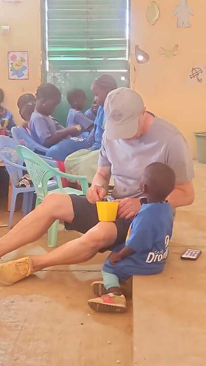 Un voluntario de Amigos de Louga comparte el desayuno con los niños de la guardería, donde la asociación alimenta cada mañana a un centenar de menores en Senegal.